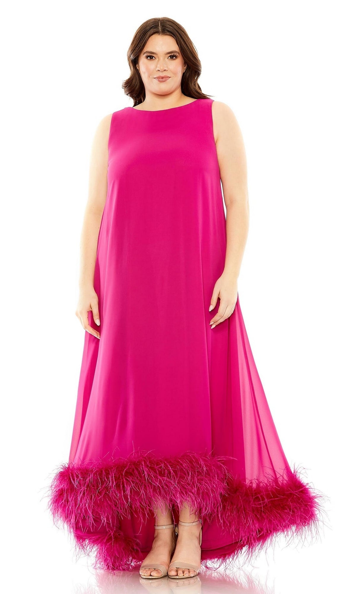 A woman in the Mac Duggal 11819 plus-size long formal dress, sleeveless and bright pink with a feathered hem, stands facing forward against a white background.